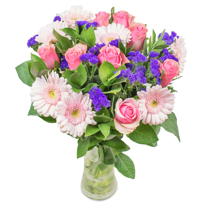 Elegantly showcased in a transparent glass vase against a pale, sunlit backdrop, this vibrant bouquet is an artful combination of approximately seven to nine classic pink roses-many just beginning to unfurl their signature spirals-and five to seven pale pink gerbera daisies, each distinguished by their full, open faces and creamy centers. Interspersed throughout the arrangement, bright purple statice adds dynamic contrast and textural variation, reminiscent of Kingston's creative energy and colorful market stalls. Deep green foliage establishes a lush, supportive base, reflecting the serenity of nearby Home Park. With water glistening around each neatly cut stem, the bouquet suggests same-day freshness and the trusted artistry of Flower Delivery Kingston. Its refined harmony of pinks and purples offers just the right sentiment for birthdays near Kingston Bridge, Mother's Day celebrations, or as a thoughtful gift brightening a local workspace. This arrangement delivers an uplifting message of joy, care, and subtle celebration-distinctly Kingston in its charm and approachable grace.